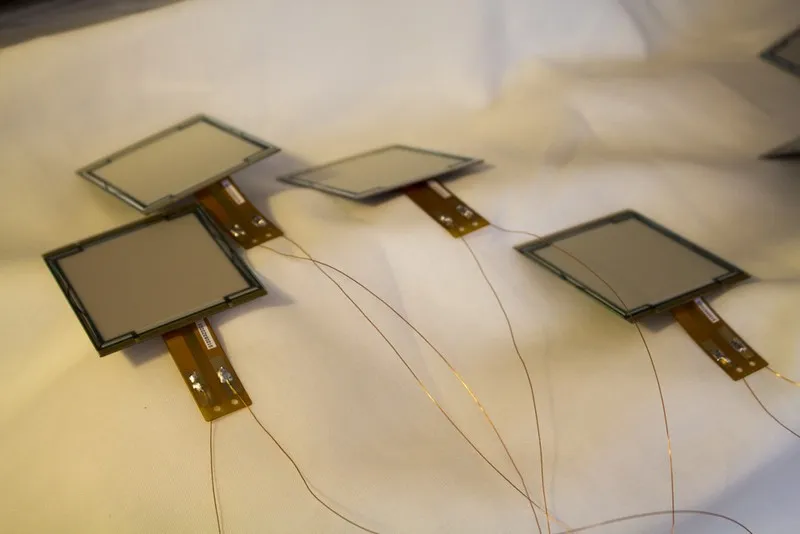 Vier OLED-Panels mit dünnen Zuleitungen auf Papier