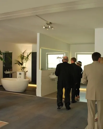 Gäste im Showroom vor kuratierter Badausstattung