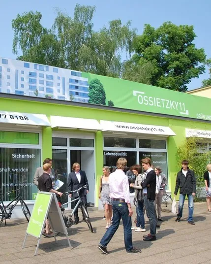 Maigrüner Showroom in der Ossietzkystraße von außen mit Besuchern