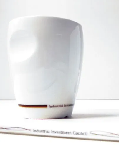 Weiße Kaffeetasse, Golfball und Stift mit IIC-Logo und Deutschlandkarte