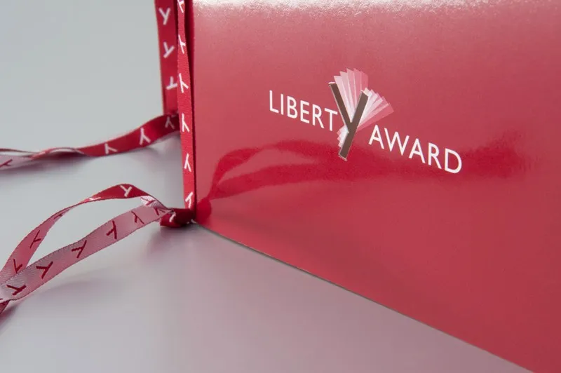 Einladungsumschlag mit Liberty-Award-Logo und rotem Band