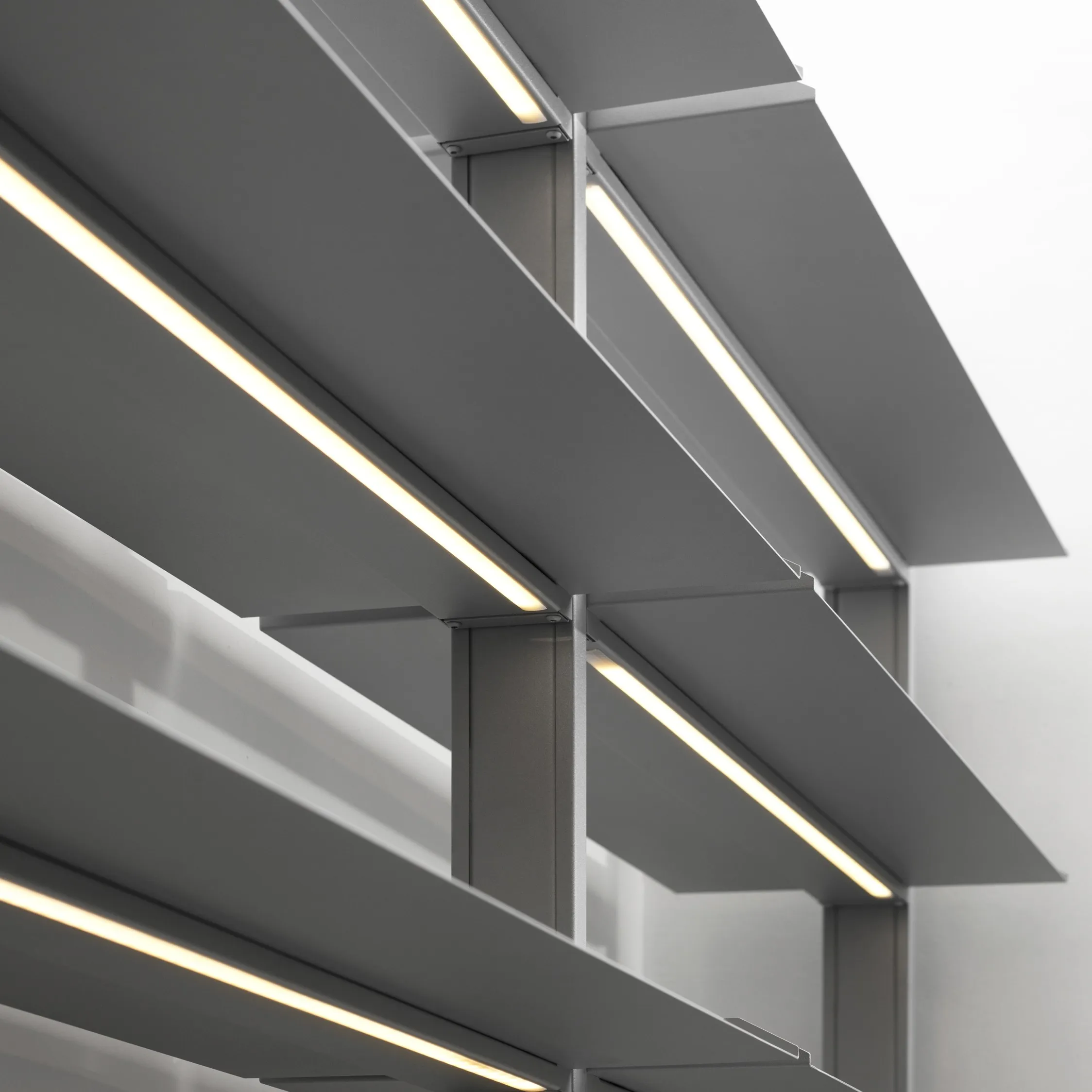Integrierte LED-Beleuchtung unter grauen, abgewinkelten SCALA Regalböden