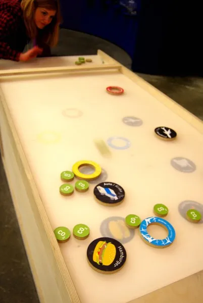 Kind am Spieltisch der Ausstellung mit Spielsteinen
