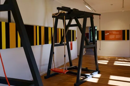 Ausstellungsraum mit Experimentiergerüst und farbigem Wandspektrum an der Wand