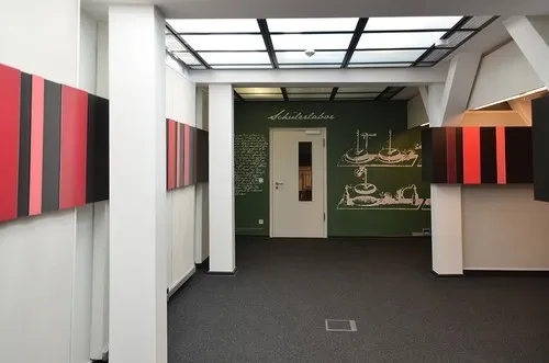 Raum mit roten und schwarzen Paneelen und Zeichnung an der Wand